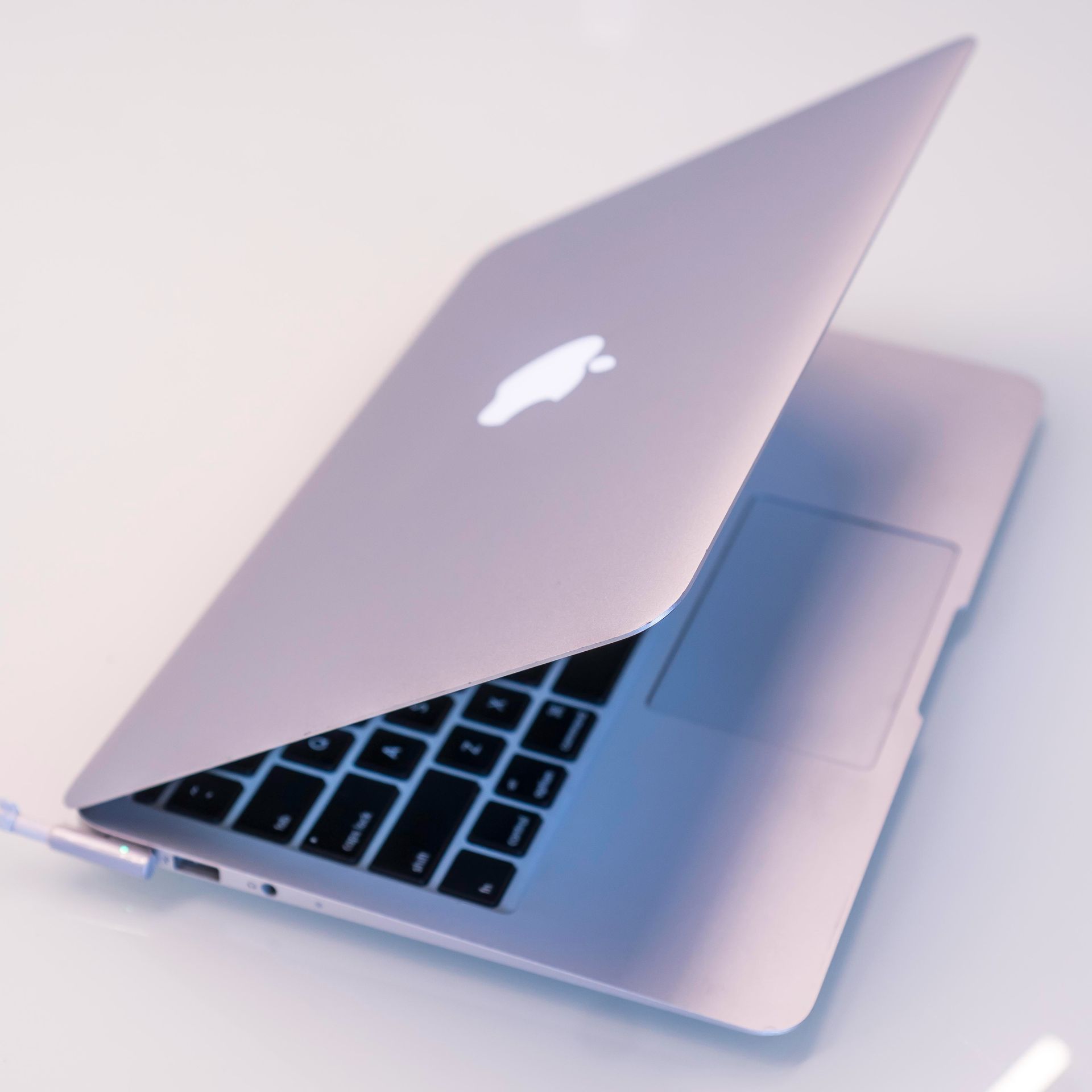 silver macbook on white table